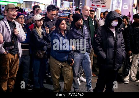 New York, USA. November 2024. Am Dienstag, 5. November 2024, am New Yorker Times Square, schweigen die Menschen meist, als sie die Ergebnisse des Präsidentschaftswahlkampfs 2024 zwischen dem ehemaligen Präsidenten Donald Trump und Vizepräsident Harris sehen, als es schien, dass Harris die Wahl verloren hätte. Einige in der Menge trugen Kleidung und Hüte, die den Vizepräsidenten unterstützten, und einige trugen Hüte, die den ehemaligen Präsidenten unterstützten. (Foto: Craig Ruttle/SIPA USA) Stockfoto