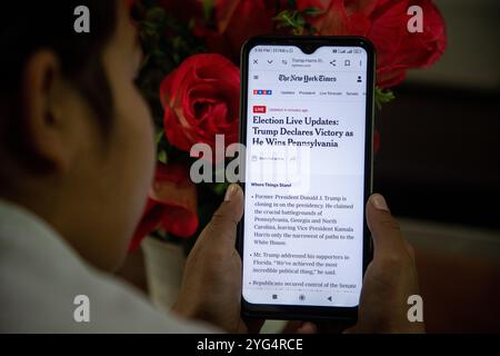 Srinagar, Indien. November 2024. Ein Mädchen hält ein Smartphone, das die Website der Zeitung New York Times zeigt, während sie auf die US-Wahlen 2024 zwischen Donald Trump und Kamala Harris in Srinagar, Indien, wartet. Die amerikanischen Wähler sind zur Wahl gegangen, um den 47. Präsidenten der Vereinigten Staaten zu bestimmen. Die Umfragen der letzten Wochen haben gezeigt, dass es zwischen dem demokratischen Präsidentschaftskandidaten Kamala Harris und dem republikanischen Präsidentschaftskandidaten, dem ehemaligen Präsidenten Donald Trump, um Präsident Joe Biden im Weißen Haus zu folgen. Quelle: SOPA Images Limited/Alamy Live News Stockfoto