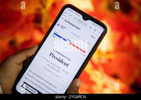 Srinagar, Indien. November 2024. Ein Mädchen hält ein Smartphone, das die Website der Zeitung Washington Post zeigt, während sie auf die Anzahl der US-Wahlen 2024 zwischen Donald Trump und Kamala Harris in Srinagar, Indien, wartet. Die amerikanischen Wähler sind zur Wahl gegangen, um den 47. Präsidenten der Vereinigten Staaten zu bestimmen. Die Umfragen der letzten Wochen haben gezeigt, dass es zwischen dem demokratischen Präsidentschaftskandidaten Kamala Harris und dem republikanischen Präsidentschaftskandidaten, dem ehemaligen Präsidenten Donald Trump, um Präsident Joe Biden im Weißen Haus zu folgen. Quelle: SOPA Images Limited/Alamy Live News Stockfoto