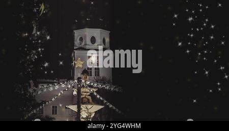 Weihnachtsbaum beleuchtet vor dem weißen Kirchengebäude. Hohes Gebäude mit einer Uhr drauf. Weihnachten. Salzburg, Österreich. Stockfoto