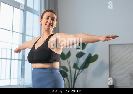 Fitness-Workout-Training. Frau, die zu Hause Fitness übt. Frauen in Übergröße, die zu Hause in der Halle sportlich trainieren. Mädchen in Sportbekleidung haben Workout Gewichtstraining zur Gewichtsreduktion. Sport und Fitness Stockfoto