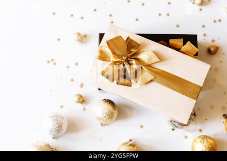 Zwei Weihnachtsgeschenkboxen, verziert mit leuchtenden goldenen Bändern auf weißem Hintergrund. Flache Lagen. Kopierbereich Stockfoto