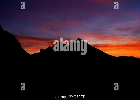 Abendlicher Blick auf KOM Ljevoreсki: Silhouetten malerischer Berggipfel vor dem farbenfrohen Sonnenuntergang. Sonnenuntergang im Komovi Naturpark, Montenegro. Stockfoto