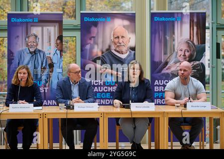 Die Diakonie Deutschland will mit der Pflegekampagne sechs Bausteine für eine gute Pflegereform den Druck auf die Politik erhoehen. Sie forderte am Mittwoch, 06.11.2024, in Berlin eine Pflegevollversicherung, die soziale Absicherung pflegender Angehoeriger und eine gesetzliche Verpflichtung für Kommunen zu einer lokalen Altenhilfeplanung im Foto vom 06.11.2024 Pressekonferenz mit vlnr. Kathrin Klinkusch, Diakonie-Pressesprecherin, Diakonie-Praesident Ruediger Schuch, die Diakonie-Sozialvorstaendin Maria Loheide und Ricardo lange, Intensivpfleger und Pflege-Aktivist, und im Hintergrund Plakat Stockfoto