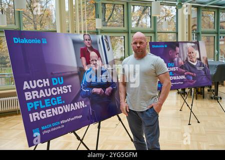 Die Diakonie Deutschland will mit der Pflegekampagne sechs Bausteine für eine gute Pflegereform den Druck auf die Politik erhoehen. Sie forderte am Mittwoch, 06.11.2024, in Berlin eine Pflegevollversicherung, die soziale Absicherung pflegender Angehoeriger und eine gesetzliche Verpflichtung für Kommunen zu einer lokalen Altenhilfeplanung im Foto vom 06.11.2024: Pressekonferenz mit Ricardo lange, Intensivpfleger und Pflege-Aktivist im Hintergrund Plakate der Kampagne auch du brauchst Pflege. Irgendwann. mit Prominenten. Siehe epd-Meldung vom 06.11.2024 NUR REDAKTIONELLE VERWENDUNG *** Diakonie Deutschl Stockfoto