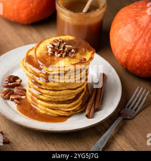 Frühstückskürbis-Pfannkuchen mit Karamell und Pekannüssen auf hölzernem Hintergrund Stockfoto