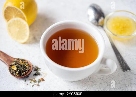 Tasse Kräutertee mit Honig und Zitrone auf hellgrauem Hintergrund, Nahansicht, gesundes Entgiftungsgetränk Stockfoto