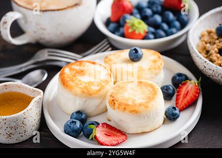 Frühstück Syrniki-Pfannkuchen mit Beeren, gesunde gebratene Käsekuchen oder Ricotta-Pfannkuchen, Quark-Krapfen Stockfoto