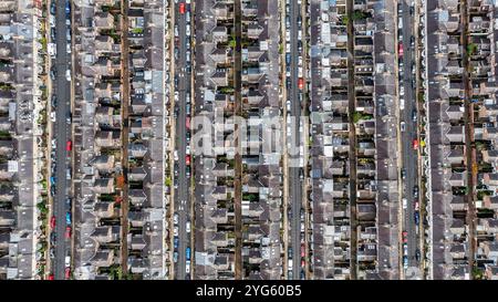 Aerila Birds Blick direkt über einem großen Sozialwohnsitz in einer britischen Stadt im Norden mit parallelen Straßen voller parkender Autos und Reihen von Run dow Stockfoto