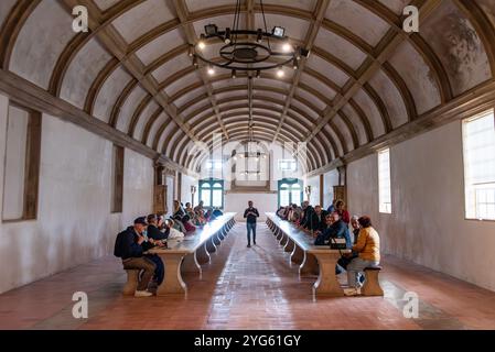 Tomar, Portugal - 2. Juni 2024 - Touristen sitzen im riesigen alten Refektorium des Klosters Christi in Tomar, Portugal, wo Mahlzeiten serviert werden Stockfoto