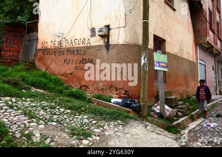 Müll wurde zur Abholung an der Straßenecke neben Grafitti hinterlassen und die Leute gebeten, sich um das Dorf zu kümmern und ihren Müll nicht draußen auf der Straße zu lassen, Coroico, Yungas Region, Bolivien Stockfoto