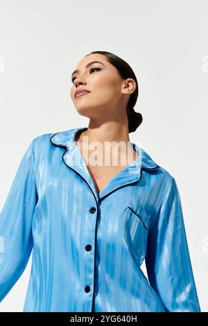 Eine junge Frau zeigt ihre Eleganz in schicker blauer Nachtwäsche, die Selbstvertrauen und Ausgewogenheit ausstrahlt. Stockfoto