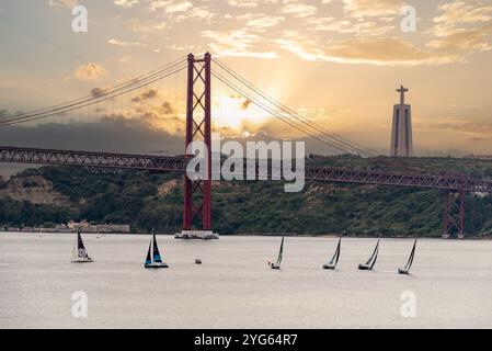 Lisboa, Portugal - 03. Juni 2024 - malerischer Sonnenuntergang über dem Fluss Tejo und der Christus-König-Statue in Lissabon, Segelboote fahren vorbei, Portugal Stockfoto