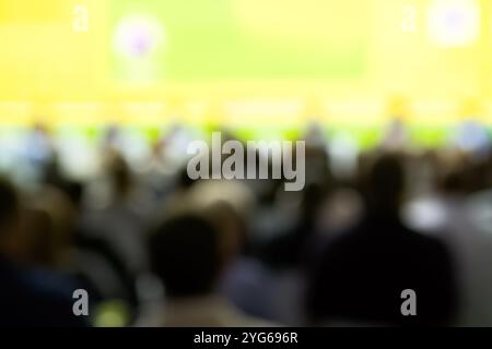 Redner hält Vortrag im Konferenzsaal bei einer Geschäftsveranstaltung. Rückansicht nicht erkennbarer Personen im Publikum im Konferenzsaal. Stockfoto