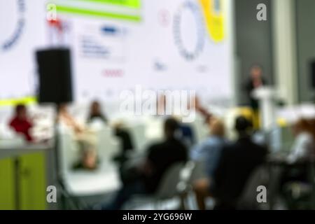 Redner hält Vortrag im Konferenzsaal bei einer Geschäftsveranstaltung. Rückansicht nicht erkennbarer Personen im Publikum im Konferenzsaal. Stockfoto