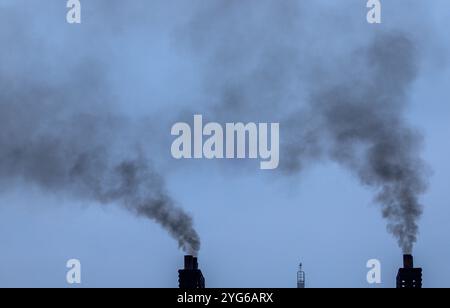 05. November 2024, Mecklenburg-Vorpommern, Rostock: Eine dunkle Rauchwolke steigt aus dem Schornstein einer Fähre, die den Hafen verlässt. Foto: Jens Büttner/dpa Stockfoto