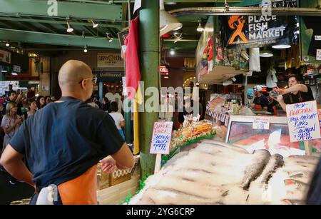 Berühmt für Fisch, der die Käufe von Kunden wirft, bevor er den Pike Place Fish Market Seattle Washington State USA einpackt Stockfoto