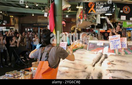 Berühmt für Fisch, der die Käufe von Kunden wirft, bevor er den Pike Place Fish Market Seattle Washington State USA einpackt Stockfoto