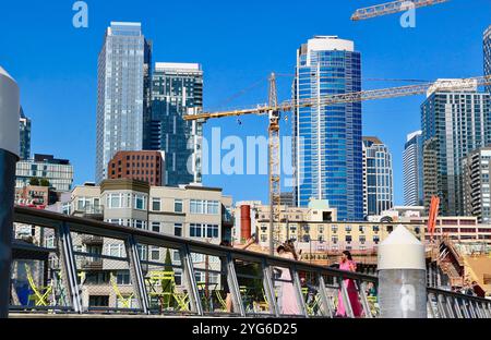 Skyline der Stadt mit einem Bauprojekt und Turmkränen entlang der Uferpromenade von einem schwimmenden Pier 62 Seattle Washington State USA Stockfoto