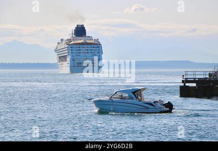 Rückansicht des norwegischen Kreuzfahrtschiffs Norwegian Cruise Lines Norwegian Sun, das auf dem Weg ist und den Seattle Washington State USA mit einem kleinen Boot im Vordergrund verlässt Stockfoto