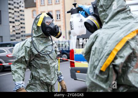 06. November 2024, Bayern, Würzburg: Bei einer Performance-Show im Rahmen der Anti-Terror-Übung „MainTex 2024“ wird ein Polizist mit Atemschutzmaske von einem anderen Polizisten in Spezialkleidung dekontaminiert. Polizei, Bundeswehr, Feuerwehr, BRK und andere Rettungsdienste demonstrieren auf der MainTEX ihre Fähigkeiten und Ausrüstung. Foto: Pia Bayer/dpa Stockfoto