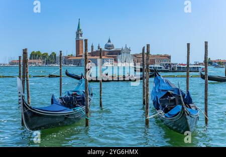 Venedig, Italien - 26. Juli 2024: Gondeln gegen die Insel San Giorgio in Venedig, Italien. Die Gondel ist der attraktivste Touristenverkehr in Venedig. T Stockfoto