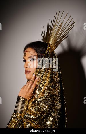 Eine atemberaubende afroamerikanische Göttin in einem leuchtend goldenen Kleid zeigt Eleganz in einem Studio-Ambiente. Stockfoto