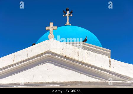 Mykonos, Griechenland - 7. Mai 2024: Blaue Kuppel einer orthodoxen Kirche mit Kreuzen und Tauben auf Mykonos vor klarem Himmel. Symbolisches Bild für griechische Kultur und Architektur. *** Blaue Kuppel einer orthodoxen Kirche mit Kreuzen und Tauben auf Mykonos vor klarem Himmel. Symbolbild für griechische Kultur und Architektur. Stockfoto