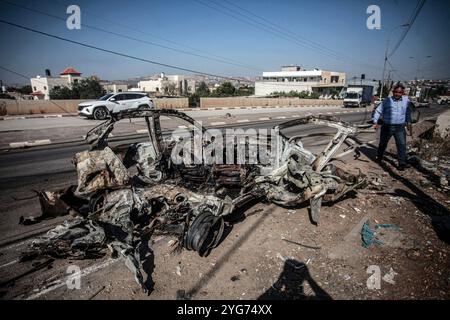 Jenin, Palästina. November 2024. Ein Mann inspiziert ein zerstörtes Auto nach einem tödlichen militärischen Angriff in der Stadt Qabatiya in der Nähe von Dschenin im nördlichen besetzten Westjordanland. (Foto: Nasser Ishtayeh/SOPA Images/SIPA USA) Credit: SIPA USA/Alamy Live News Stockfoto