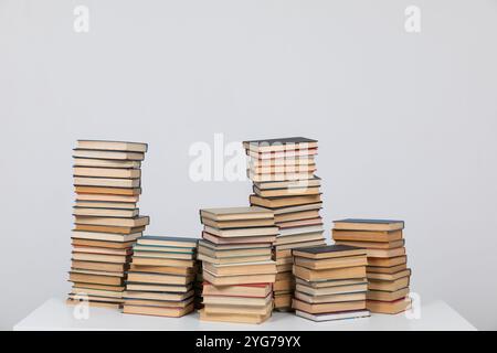 Viele Stapel Bücher zum Studium in der Bibliothek auf grauem Hintergrund Stockfoto