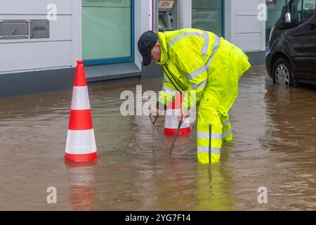Cork County Council Worker kämpft bei Überschwemmungen in Bantry, West Cork, Irland, um einen Abfluss zu beseitigen. Stockfoto