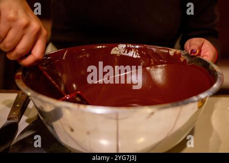 Schokoladenmischerin, die Schokolade in einer Rührschüssel mischt Stockfoto