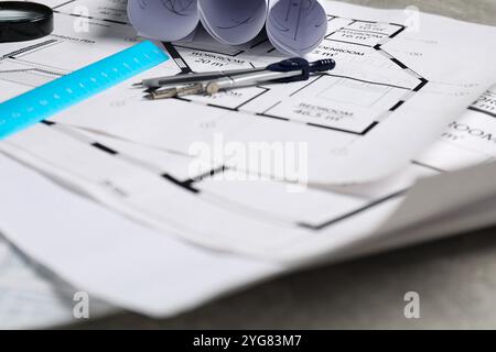 Verschiedene Architekturzeichnungen, Trennzeichen und Lineal auf grauem Tisch, Großansicht Stockfoto