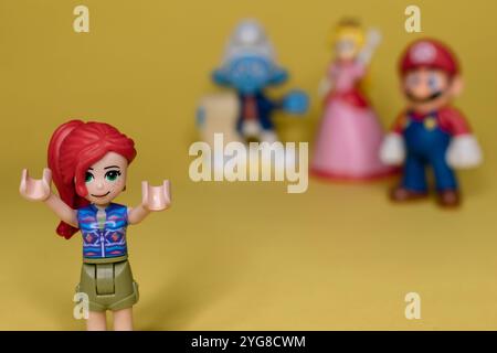 Verschiedene Gruppen von Film- und Spielfiguren auf gelbem Hintergrund Stockfoto