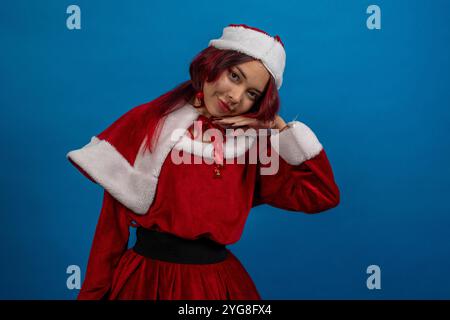 Eine Frau in einem roten Weihnachtsmann-Outfit posiert für ein Foto Stockfoto