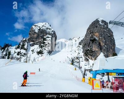 Olympische Abfahrt Olimpia 1 in Cortina d’Ampezzo in den Dolomiten, Italien. Der steilste Teil zwischen großen Felsen. Skilift und nicht erkennbare Skifahrer. Stockfoto