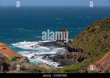 Die Küste von Cape Schanck und Pulpit Rock mit zerklüfteten Felsküsten und Wellen, die an einem warmen, sonnigen Tag gegen sie krachen. Stockfoto