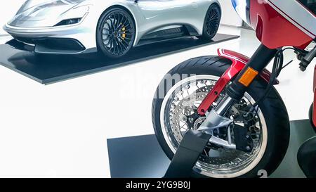 Seitenansicht eines luxuriösen Sportwagens mit rotem Motorradvorderrad Stockfoto