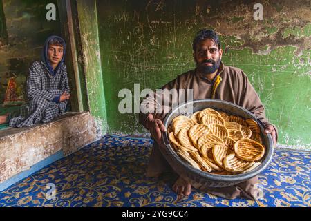 Raiyar Beruwa, Khan Sahib Tehsil, Jammu und Kaschmir, Indien. Ein Bäcker mit frisch gebackenem Fladenbrot. Stockfoto