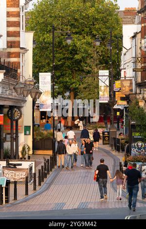 Shopper spazieren auf der Fußgängerzone Winchester Street (auch bekannt als Spitze der Stadt) in der späten Nachmittagssonne in Basingstoke, Großbritannien. Konzept: Wirtschaft Stockfoto