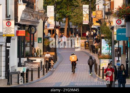 Shopper spazieren auf der Fußgängerzone Winchester Street (auch bekannt als Spitze der Stadt) in der späten Nachmittagssonne in Basingstoke, Großbritannien. Konzept: Wirtschaft Stockfoto