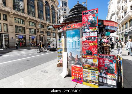 Madrid, Spanien - 9. april 2024, - auf der Gran Via in Madrid, Spanien, steht ein kunstvoller, farbenfroher Zeitungsstand, der an einem sonnigen Morgen für Geschäftsleute geöffnet ist. Stockfoto