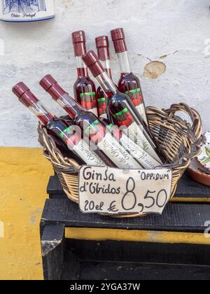 Portugal, Obidos. Ein Korb mit Ginja de Obidos - ein traditioneller lokaler Likör, der aus Sauerkirschen mit Brandy hergestellt wird. Stockfoto