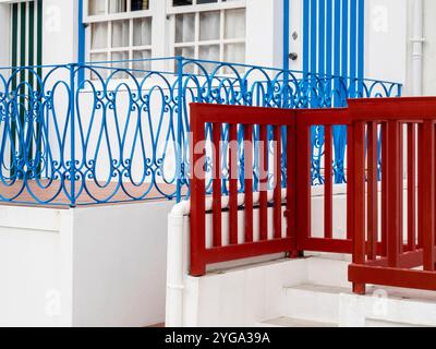 Portugal, Costa Nova. Rot-blaues Geländer vor einem der traditionellen, mit Süßigkeiten gestreiften Strandhäuser. Stockfoto