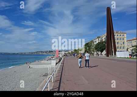 Nizza, Frankreich - 24.09.2024: Junges Paar spaziert am sonnigen Sommermorgen auf der Promenade des Anglais neben dem Strand und dem Mittelmeer. Stockfoto