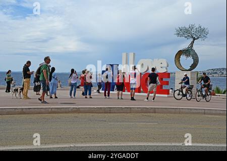 Nizza, Frankreich - 24.09.2024: Die Leute vor der Statue I Love Nizza auf der Promenade des Anglais am sonnigen Sommermorgen. Stockfoto