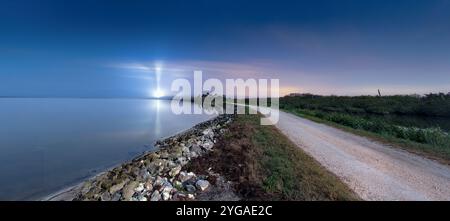 Biolab Road im Merritt Island National Wildlife Refuge, mit Launch Complex 39A, der den Himmel beleuchtet. Stockfoto