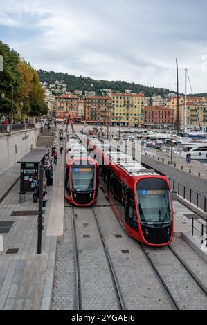 Nizza, Frankreich - 24. September 2024: Rote Straßenbahnen halten am sonnigen, bewölkten Sommermorgen am Port de Nice. Stockfoto