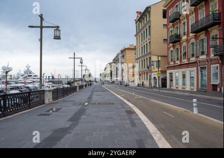 Nizza, Frankreich - 24.09.2024: Farbenfrohe Wohngebäude mit Blick auf den Hafen von Port de Nice am sonnigen, bewölkten Sommermorgen. Stockfoto