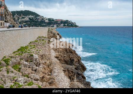Nizza, Frankreich - 24.09.2024: Felsige Küste neben der Promenade des Anglais am windigen Sommermorgen. Stockfoto
